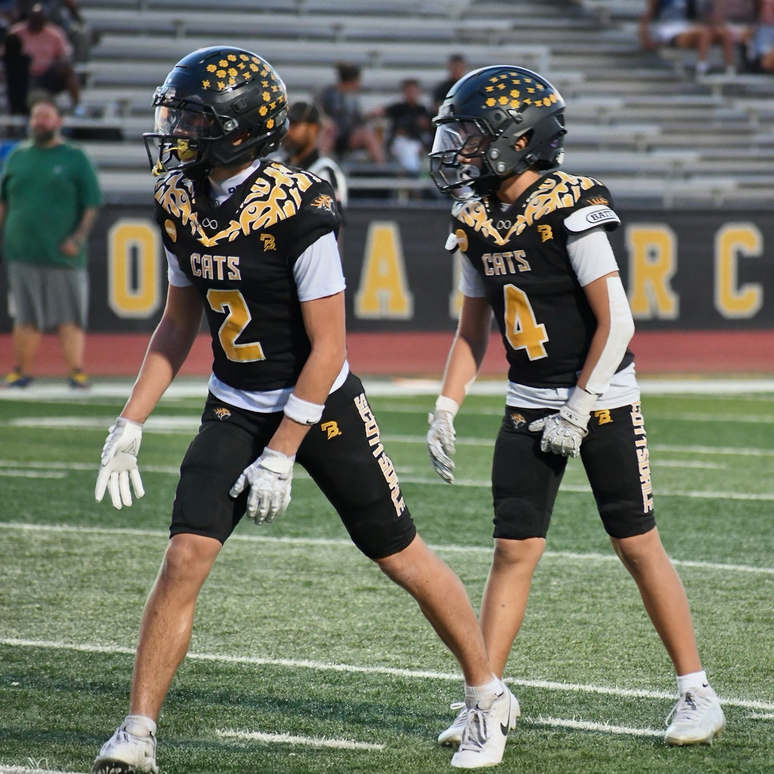 Scottsdale Sabercats players in black and gold uniforms on the football field